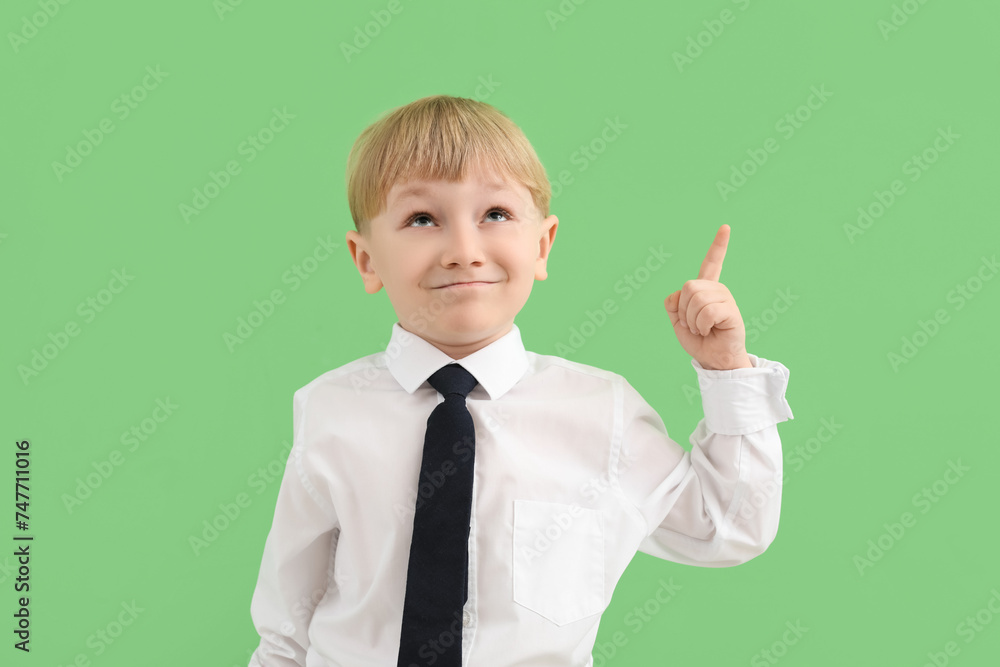Funny little businessman pointing at something on green background Funny little businessman pointing at something on green background