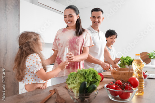 Little children with their parents cooking in kitchen