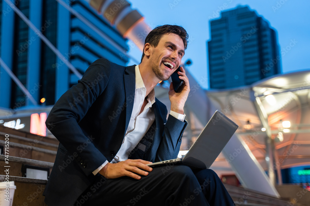 Caucasian businessman talk on mobile phone while work in city at night. Caucasian businessman talk on mobile phone while work in city at night.