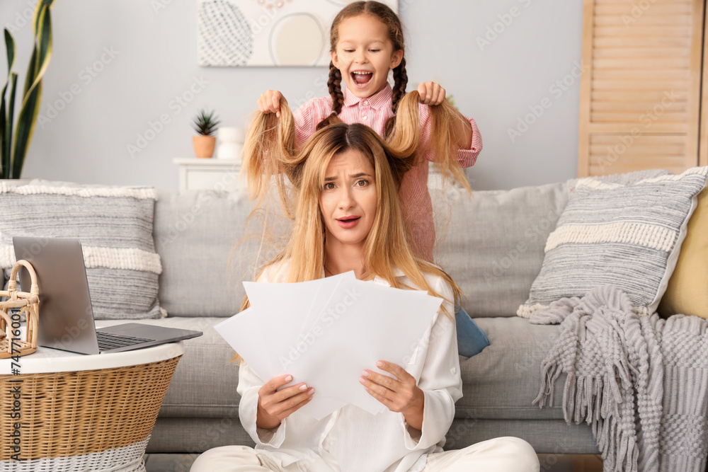Working young woman stressed of her naughty little daughter at home Working young woman stressed of her naughty little daughter at home