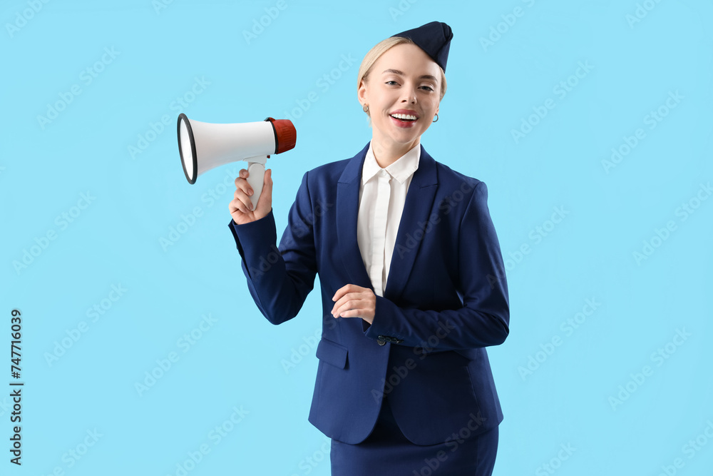 Young stewardess with megaphone on blue background Young stewardess with megaphone on blue background