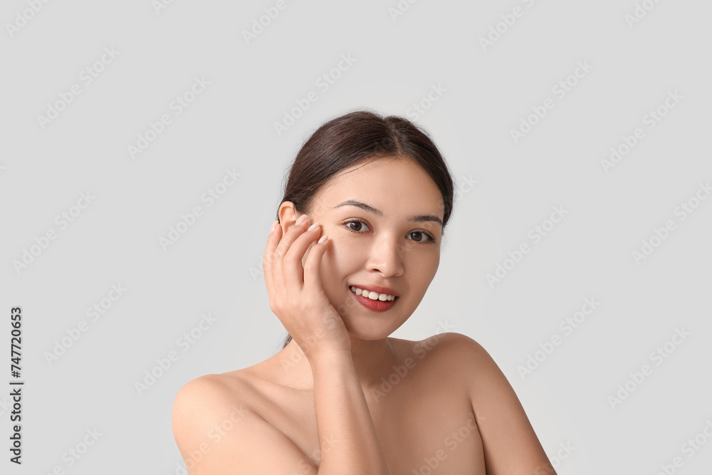 Beautiful young Asian woman on grey background Beautiful young Asian woman on grey background