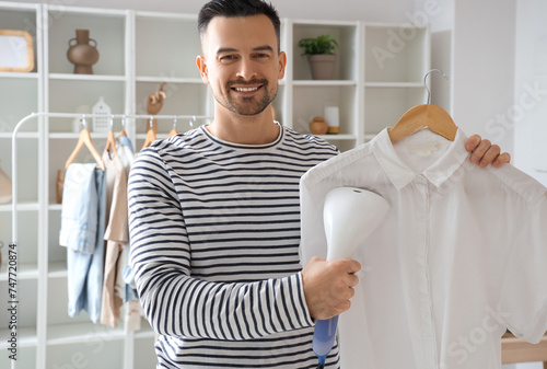 Handsome man steaming shirt...