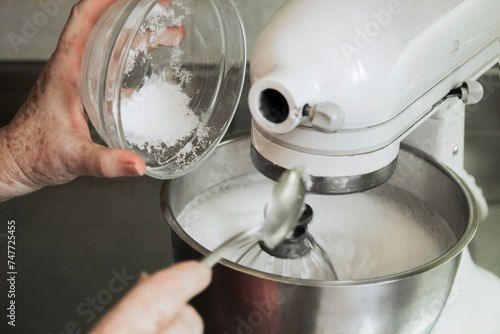 Hands of an old woman pouring sugar into a blender