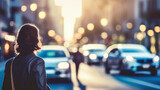 Young woman walking on the street in the city at sunset. Blurred background.