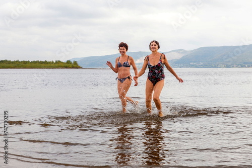 athletic elderly women run on the waves of the river