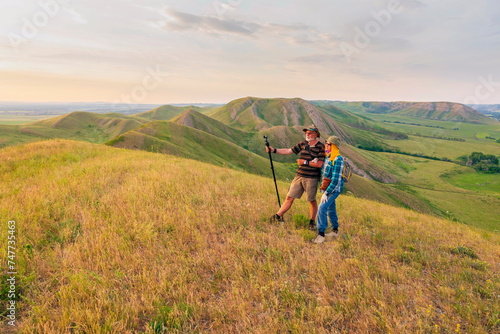 happy mature married couple traveling through the Ural mountains on a summer day