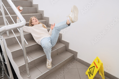 Young woman fell down on wet steps in stairway. Trauma concept