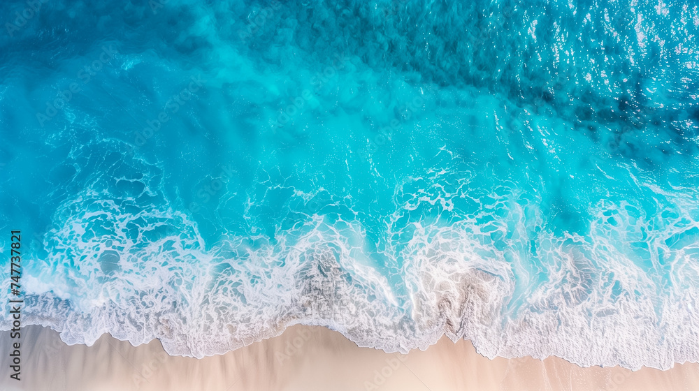 Aerial view of turquoise sea waves meeting a sandy beach - perfect for travel, summer vacation, and tropical destinations concepts