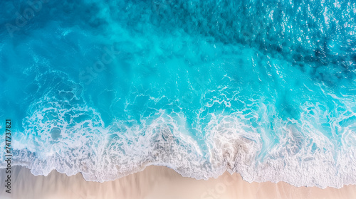 Aerial view of turquoise sea waves meeting a sandy beach - perfect for travel, summer vacation, and tropical destinations concepts