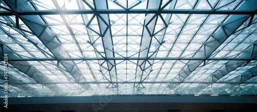 The ceiling of this building is constructed entirely of glass, creating a unique lattice pattern that allows natural light to filter through. The glass roof provides a view of the sky above,