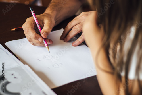 Homeschooling Dad teaching enthusiastic young child how to draw.