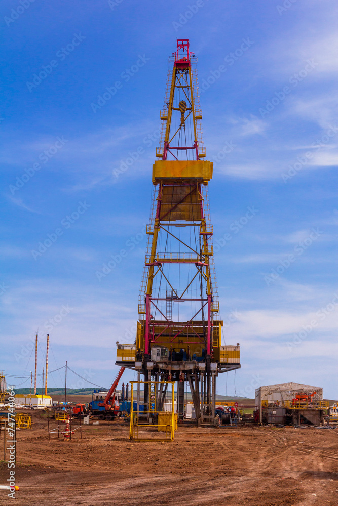 oil and gas drilling rig on a summer sunny day against a blue sky oil and gas drilling rig on a summer sunny day against a blue sky
