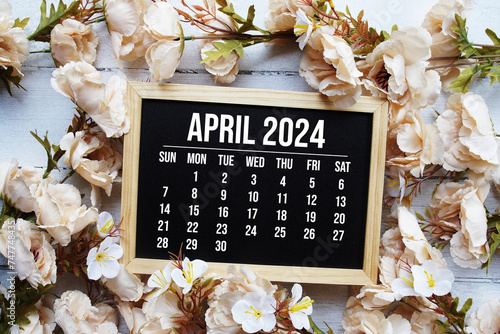 April 2024 monthly calendar with flower bouquet decoration on wooden background