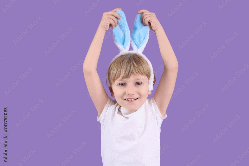 Cute little boy in bunny ears on purple background. Easter celebration Cute little boy in bunny ears on purple background. Easter celebration