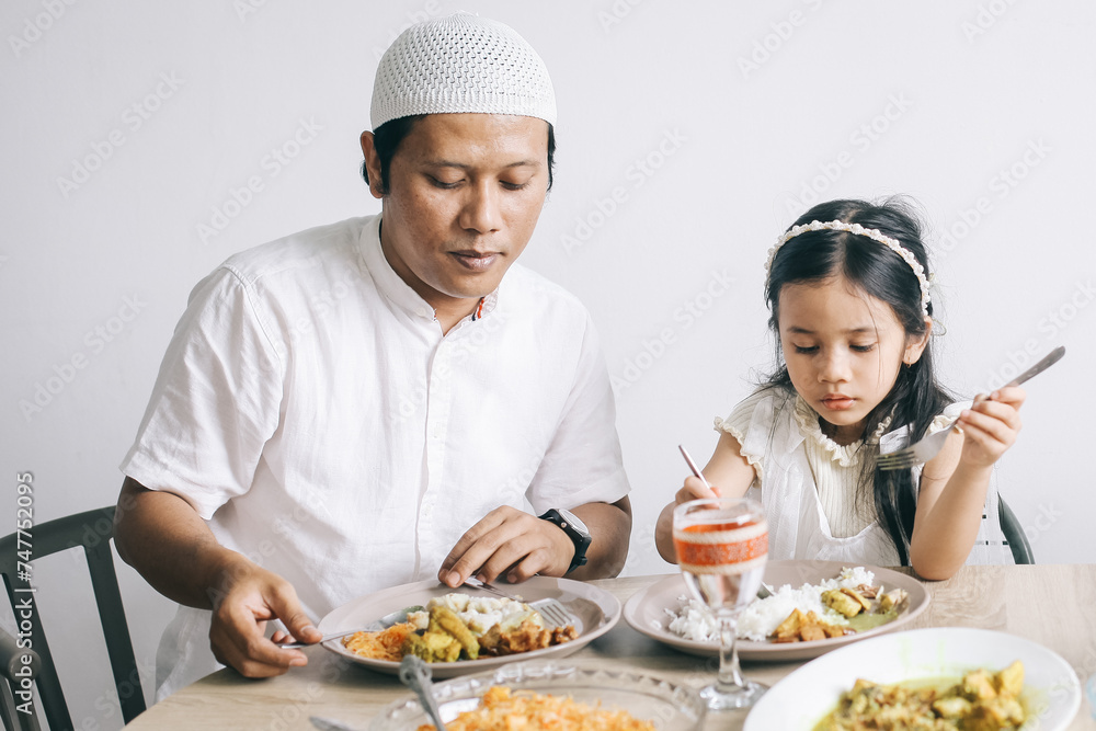Muslim family enjoying special food at dining room during Eid Mubarak moment. Muslim family enjoying special food at dining room during Eid Mubarak moment.