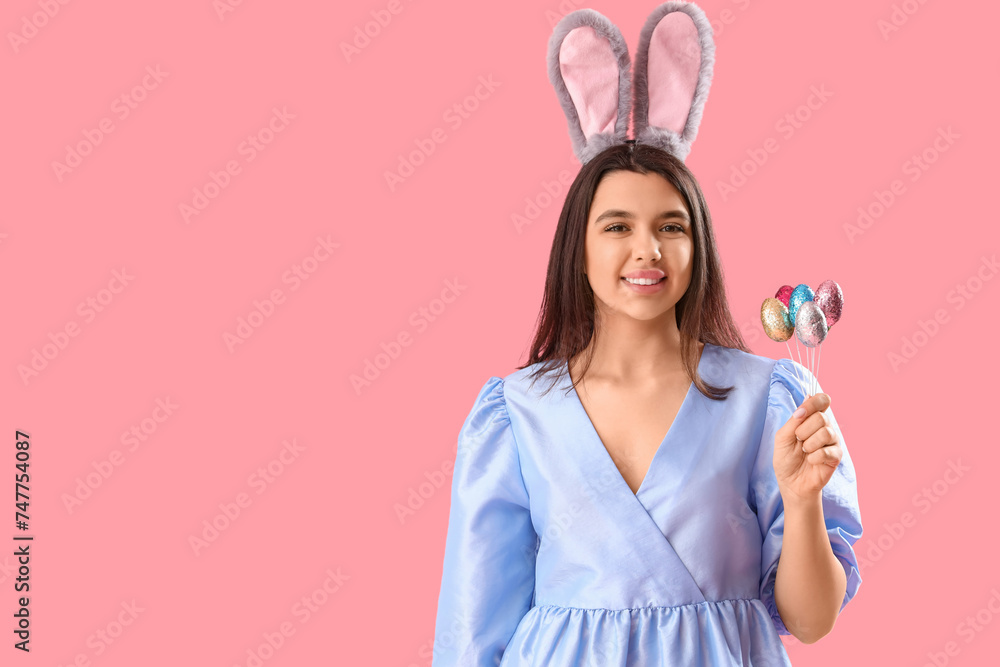 Beautiful young woman in bunny ears with Easter eggs on pink background Beautiful young woman in bunny ears with Easter eggs on pink background
