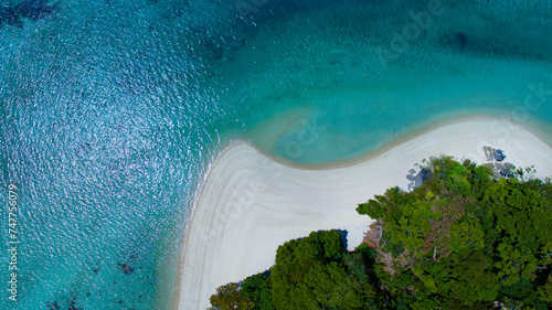 The aerial view of white sand beach tropical with seashore as the island in a coral reef ,blue and turquoise sea Amazing nature landscape with blue lagoon 