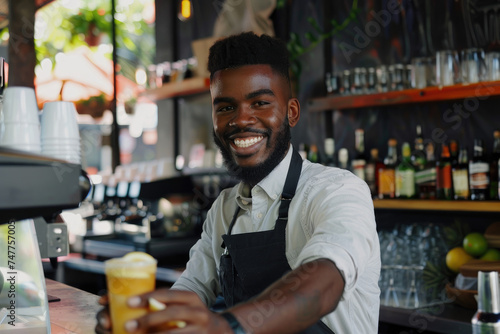 Happy waitor serving drinks while working in cafe photo