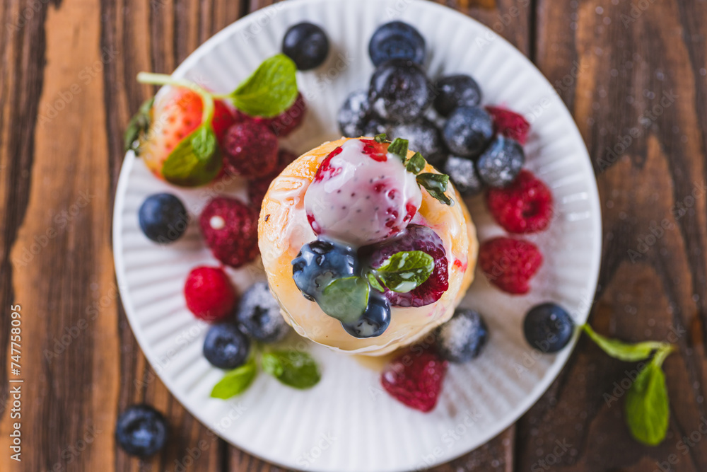 Cheesecakes served with berries and condensed milk Cheesecakes served with berries and condensed milk