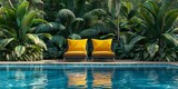 Modern poolside oasis with vibrant yellow cushions on designer chairs amidst tropical flora