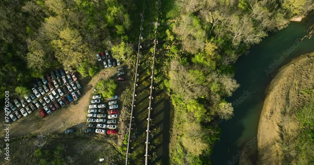 A junkyard with rows of cars by a river in fayetteville, ar during the day, aerial view A junkyard with rows of cars by a river in fayetteville, ar during the day, aerial view