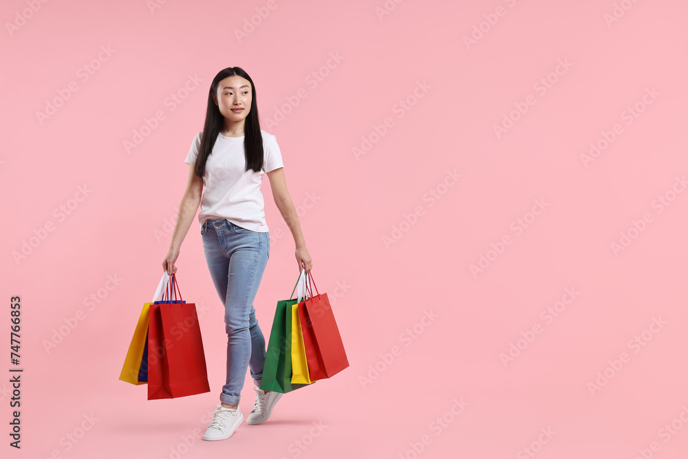 Beautiful woman with shopping bags on pink background. Space for text Beautiful woman with shopping bags on pink background. Space for text