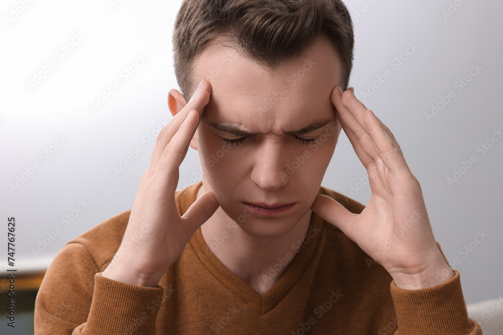 Sad man suffering from headache at home Sad man suffering from headache at home