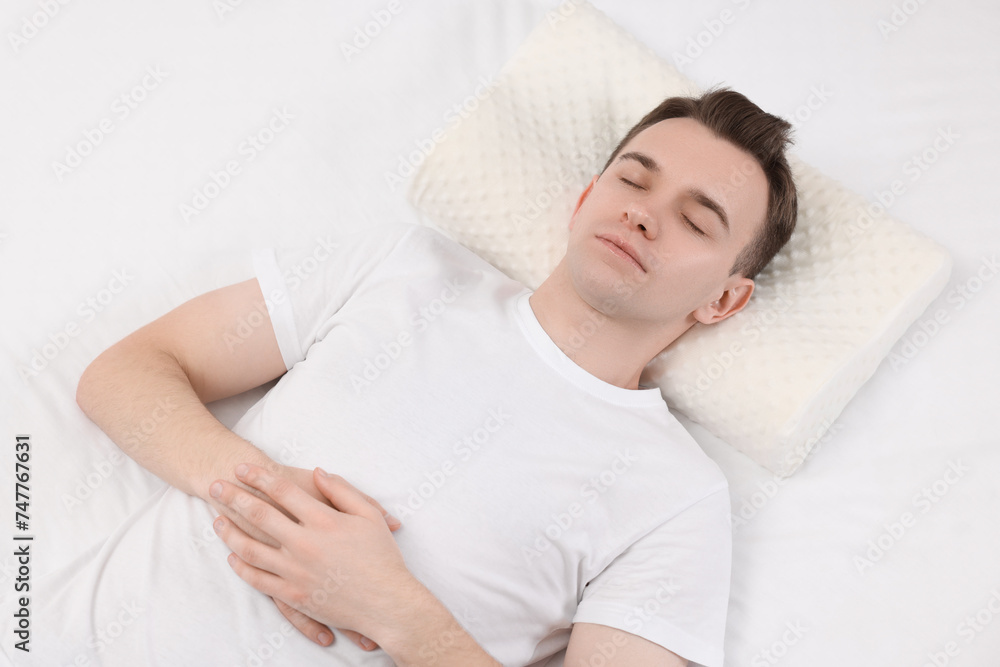 Man sleeping on orthopedic pillow in bed Man sleeping on orthopedic pillow in bed