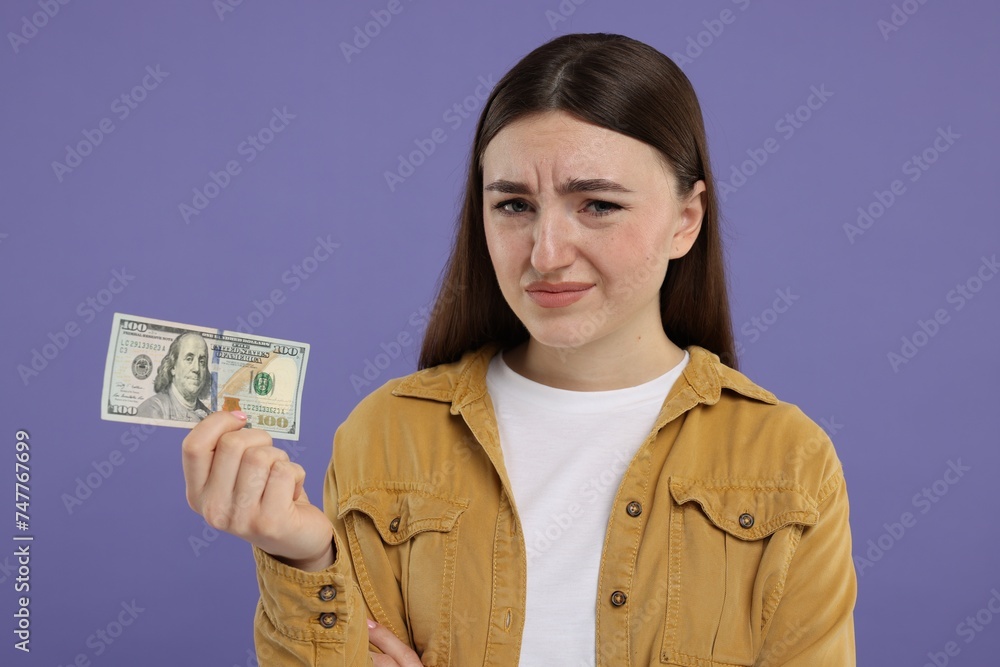 Sad woman with dollar banknote on purple background Sad woman with dollar banknote on purple background