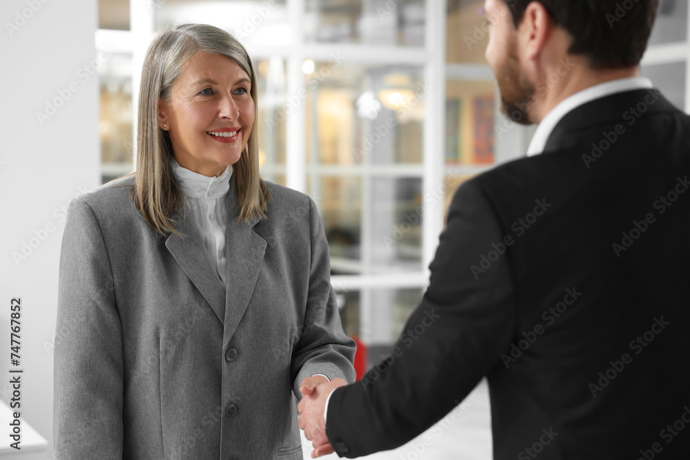 Lawyer shaking hands with client in office Lawyer shaking hands with client in office