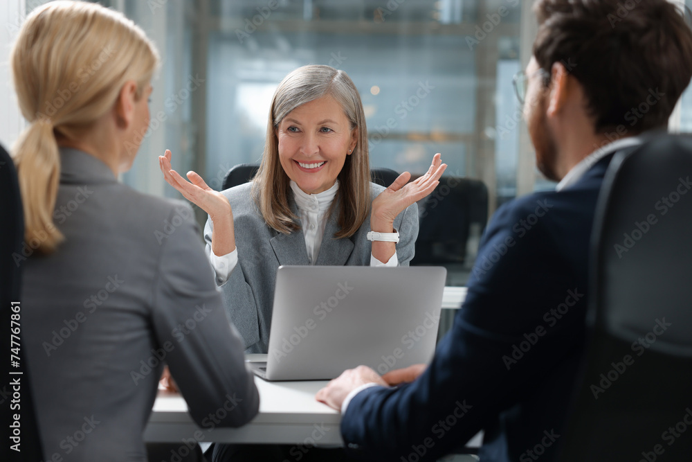 Lawyer working with clients at table in office Lawyer working with clients at table in office