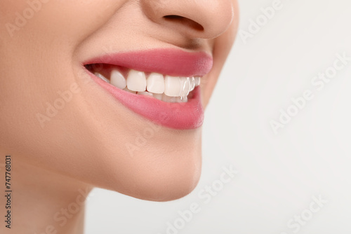 Young woman with beautiful smile on white background, closeup