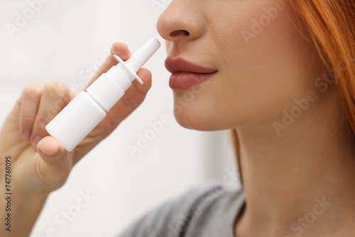 Medical drops. Woman using nasal spray at home, closeup photo