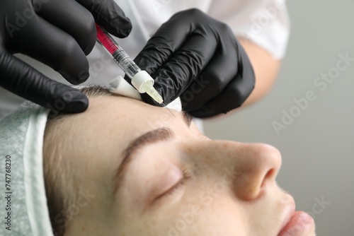 Cosmetologist giving facial injection to patient in clinic  closeup. Cosmetic surgery