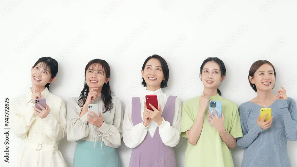 笑顔でスマホを使うミドル女性グループ