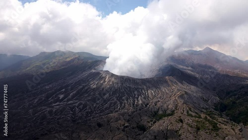 4k aerial drone footage of the dangerous and shivering moment of an eruption, with heavy clouds above the crater of the active volcano, Mount Bromo photo