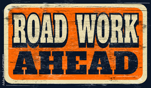 Old worn road work ahead sign on wood