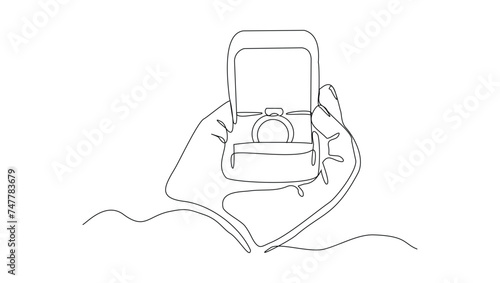 Continuous single line sketch drawing of hand holding wedding couple rings in open elegant box. One line art of engagement and love marriage symbol vector illustration