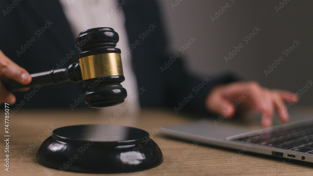 Woman judge hand holding gavel to bang on sounding block in the court room. Woman judge hand holding gavel to bang on sounding block in the court room.