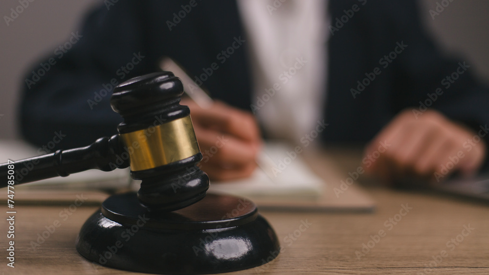 Woman judge hand holding gavel to bang on sounding block in the court room. Woman judge hand holding gavel to bang on sounding block in the court room.