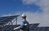 太陽光発電施設を点検するエンジニア
