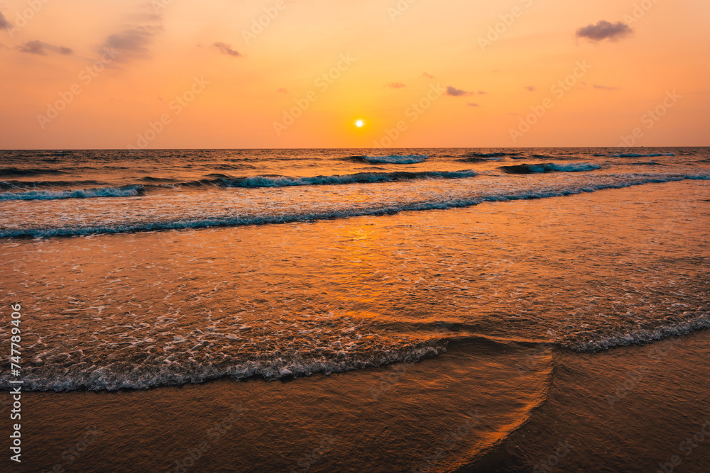 Sunset on the beach and orange sea waves