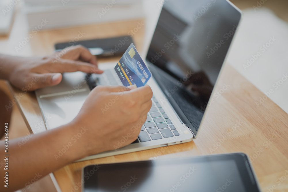 Fototapeta premium Close Up man hands holding credit card using online shopping with laptop, Online payment at home or office, internet banking, future lifestyle ideas for spending or entrepreneurs in ordering products