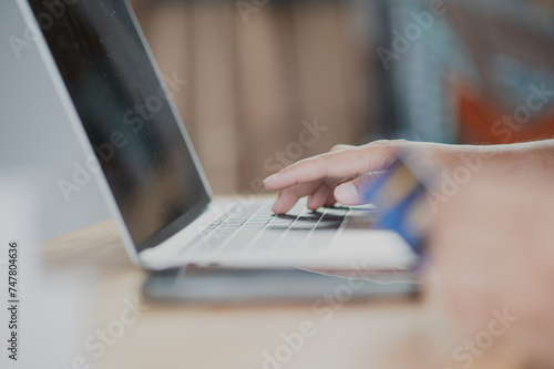 Close Up man hands holding credit card using online shopping with laptop, Online payment at home or office, internet banking, future lifestyle ideas for spending or entrepreneurs in ordering products