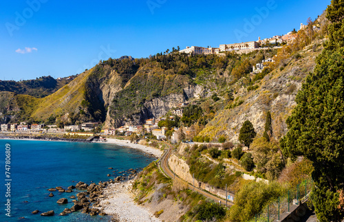 Panoramic view of Taormina shore at Ionian sea with Castello Saraceno castle, Giardini Naxos and Villagonia towns in Messina region of Sicily in Italy photo