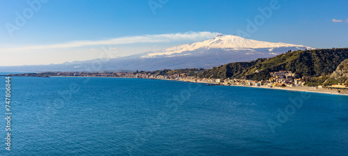 Panoramic view of Taormina shore at Ionian sea with Giardini Naxos and Villagonia towns and Mount Etna volcano in Messina region of Sicily in Italy