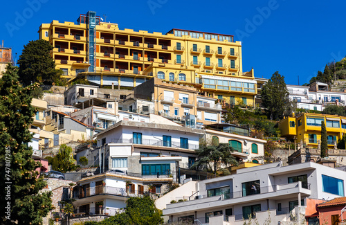 Panoramic view of Taormina houses and residences on slope of Monte Tauro rock over Ionian Sea shore in Messina region of Sicily in Italy photo