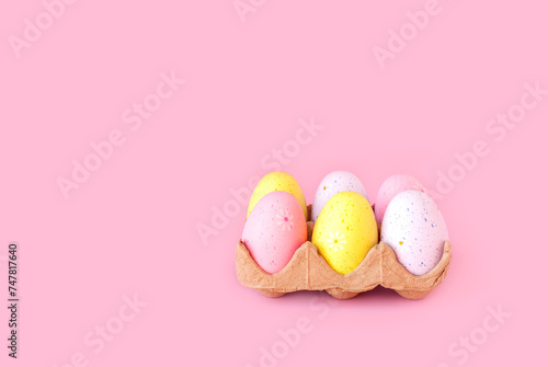 Eco basket with colorful easter eggs on pastel light pink background. minimalistic decoration, minimal composition. Front view, place for text, banner