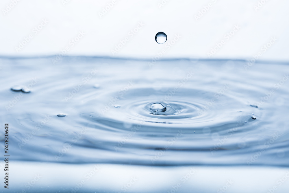 A drop bouncing off clean, clear water, creating a splash effect A drop bouncing off clean, clear water, creating a splash effect